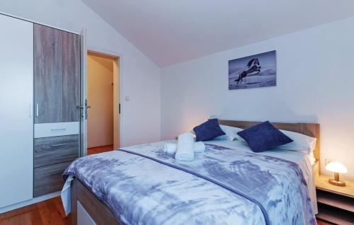 ein Schlafzimmer mit einem großen Bett mit blauen Kissen in der Unterkunft Apartman Marina in Murvica