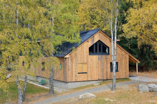a wooden cabin with a black roof at Montanie Resort in Desná