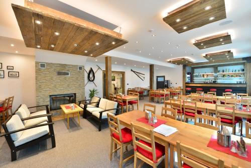 a restaurant with tables and chairs and a fireplace at Montanie Resort in Desná