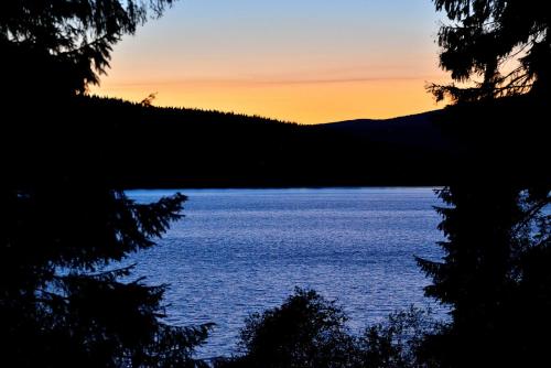 a view of a body of water at sunset at Montanie Resort in Desná