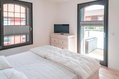 um quarto com uma cama, uma TV e uma janela em Hafenanker em Barth