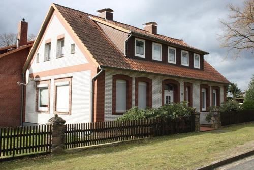 a house with a fence in front of it at Heidezeit - Ferienwohnungen in Müden in Faßberg