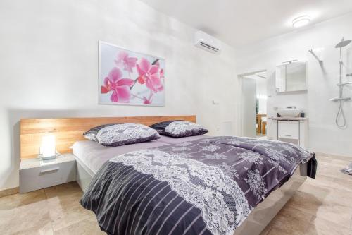 a bedroom with a bed with a purple and white comforter at Dalmata Lounge in Starigrad
