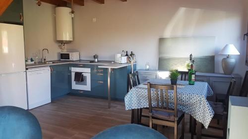 kuchnia z niebieskimi szafkami i stołem z krzesłami w obiekcie Casita Junto al Río Deva w mieście Vilde