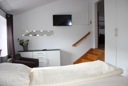 a bedroom with a bed and a tv on the wall at Heidezeit - Ferienwohnungen in Müden in Faßberg