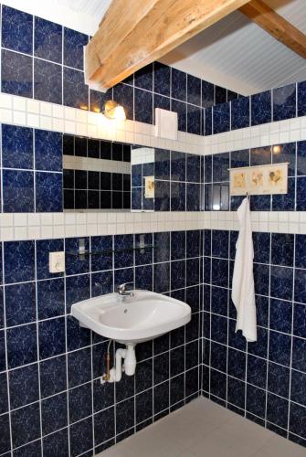 a blue tiled bathroom with a sink at Weibos B&B Camperplaats in Schijndel