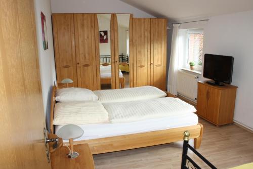 ein Schlafzimmer mit einem Bett und einem TV in der Unterkunft Ferienwohnungen Manne Peters in Müden in Faßberg