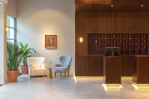 a waiting room with two chairs and a television at Vaeshartelt Maastricht in Maastricht