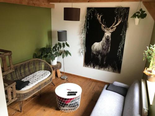 a living room with a painting of a deer on the wall at Les Gîtes du Racème in Blienschwiller
