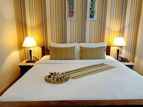 a bedroom with a white bed with two lamps at Casa Blanca Boutique Hotel - SHA Plus in Phuket Town