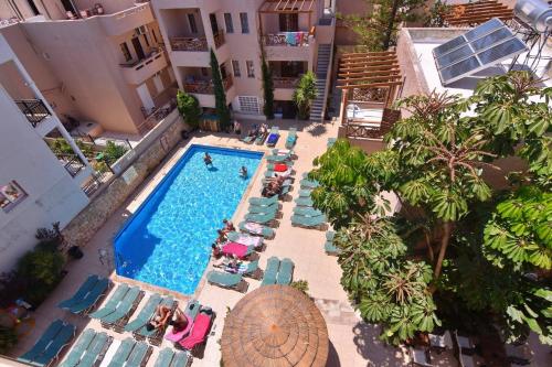 an overhead view of a swimming pool with chairs and people at 24 Seven Boutique Hotel in Malia