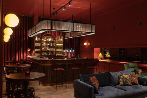 a bar in a room with a couch and tables at Vaeshartelt Maastricht in Maastricht