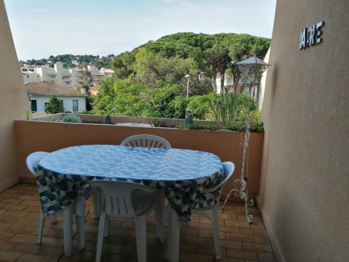 a blue table and chairs on a balcony with a view at La Calypso in Cavalaire-sur-Mer