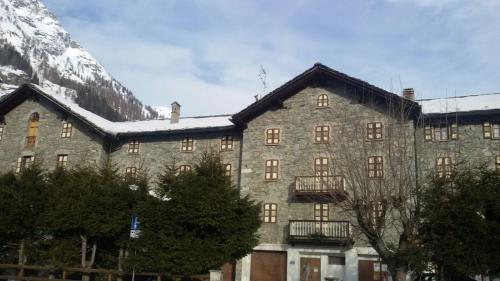 a large stone building with a mountain in the background at Casa Principe in Gressoney-Saint-Jean