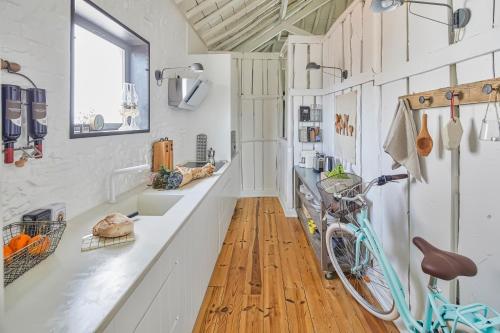 una cocina con paredes blancas y una bicicleta en una barra en Casa Branca do Olival, en Alcácer do Sal