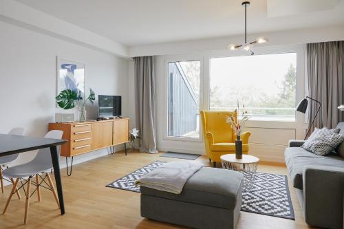 a living room with a couch and a table at Welcome in - Ferienwohnung 'Tremonia', gegenüber der Piste mit Balkon in Winterberg