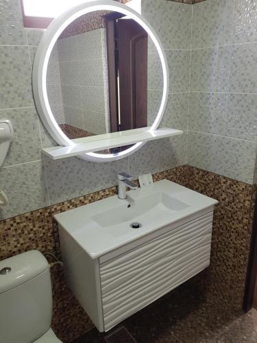 y baño con lavabo blanco y espejo. en Villa Lotus en Deva