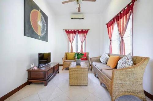 a living room with a couch and a tv at Palm Village in Rawai Beach