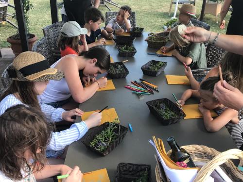 a group of children sitting around a table with plants at Glamping Diacceroni in Villamagna