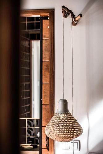 a lamp hanging from a wall next to a mirror at Lemon Tree Stay in Faro
