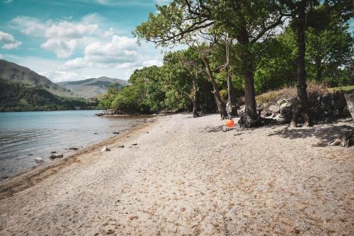 a sandy beach next to a body of water at Lodge at Loch Lomond in Glasgow