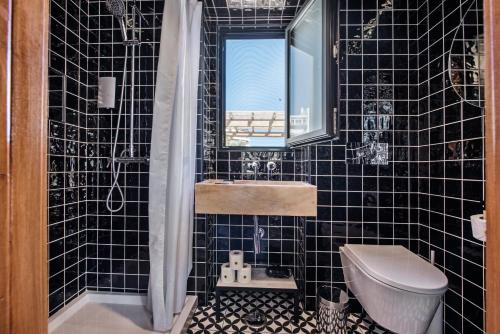 ein schwarz gefliestes Bad mit einem Waschbecken und einem WC in der Unterkunft Lemon Tree Stay in Faro