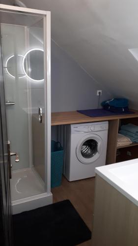 a laundry room with a washing machine and a washer at Gîte LES CHANTS DU CREPUSCULE in Marchésieux