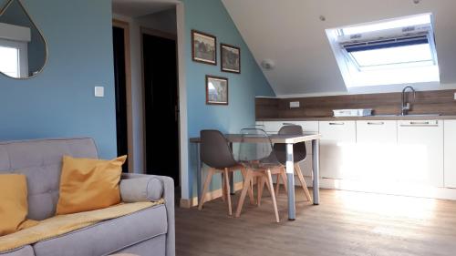 un salon avec un canapé et une table dans l'établissement Gîte LES CHANTS DU CREPUSCULE, à Marchésieux