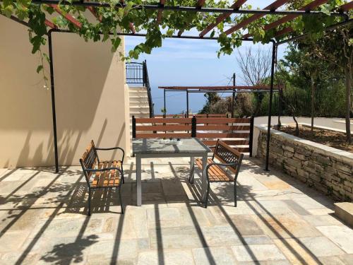 a table and chairs on a patio with a pergola at Elenis Vista Mare in Kalamaki