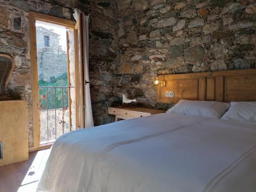 1 dormitorio con cama y ventana grande en Casa de La Roca - Only Adults., en Vilallonga de Ter