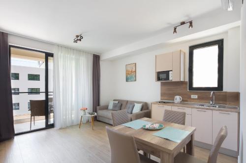 a kitchen and living room with a table and a kitchen and a dining room at Apartments Djuro Rafailovic in Budva