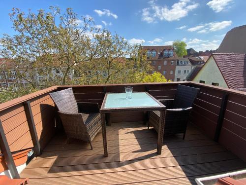 a wooden deck with a table and chairs on a balcony at holiday-apartments in Bremen