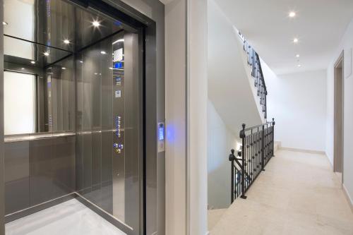 a glass elevator in a house with a staircase at Apartments Djuro Rafailovic in Budva