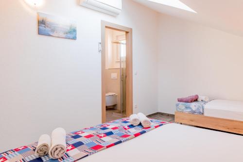 a bedroom with a bed and two slippers on it at Apartments Žilić in Kastel Stari