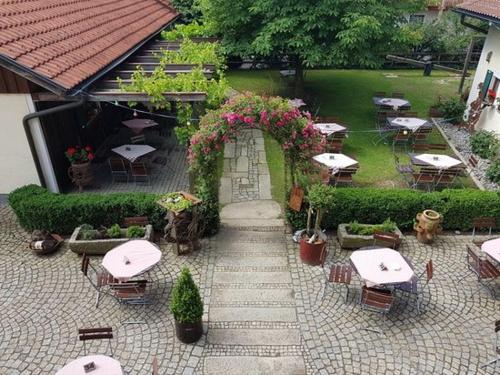 an outdoor patio with tables and chairs and flowers at Landgasthof Zum Kirchenwirt in Kellberg