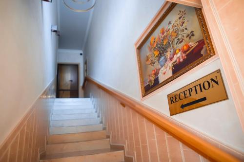 a staircase in a building with a magnification sign on the wall at Aruna Hotel in Astana