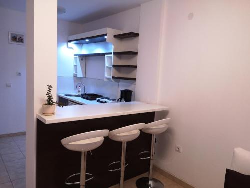 a small kitchen with two stools at a counter at Villa Eros Apartments in Struga