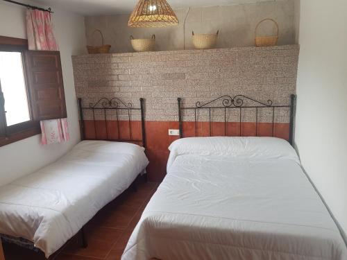 two beds in a small room with aermottermottermott at Casa Rural La Encina 2 in Lanjarón