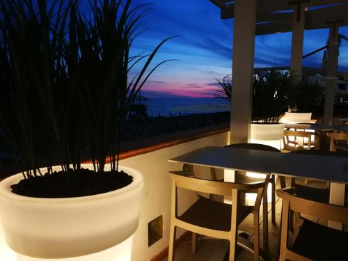 a balcony with a table and chairs and a sunset at Hotel Tirreno in Latina