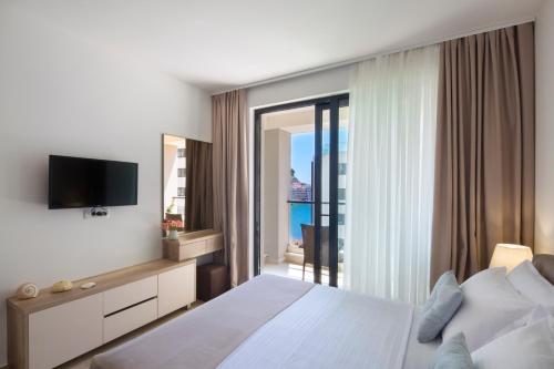 a hotel room with a bed and a large window at Apartments Djuro Rafailovic in Budva