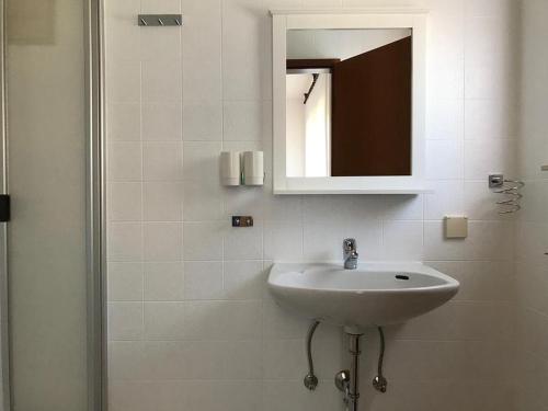 W białej łazience znajduje się umywalka i lustro. w obiekcie Ferienwohnung Rotensol w mieście Bad Herrenalb