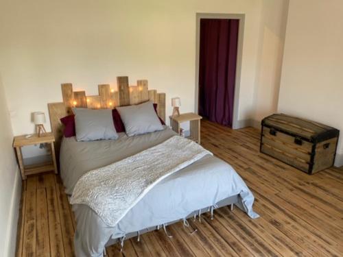 a bedroom with a large bed with a wooden headboard at Maison du Tamaris in Mosson