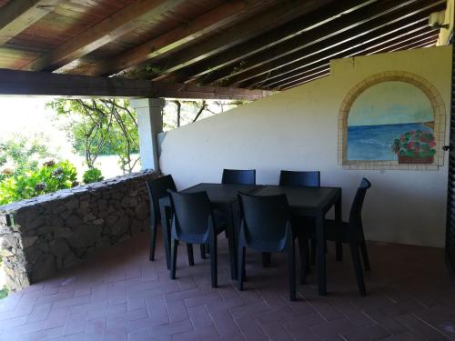 - une table et des chaises noires sur la terrasse dans l'établissement Visit San Teodoro, à San Teodoro
