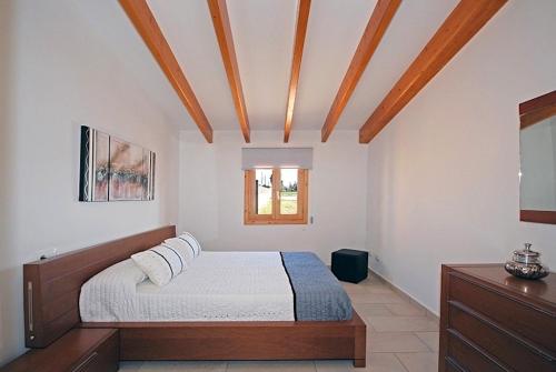 a bedroom with a bed and a wooden ceiling at Vinagrella in Llubí