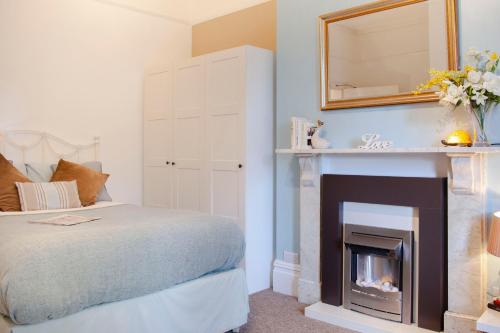 a bedroom with a bed and a fireplace at Bournemouth apt for 2 Parking Walk to town & beach - Treeside Suite in Bournemouth