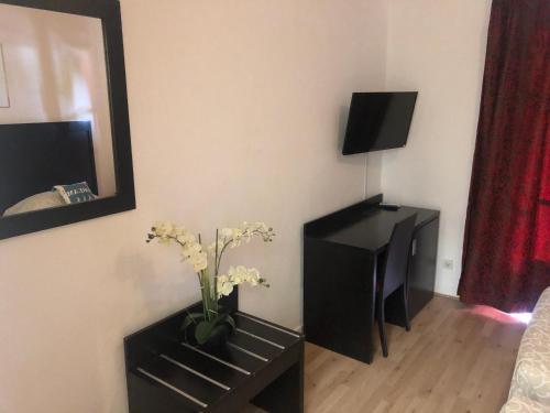 Una televisión o centro de entretenimiento en Hotel Aurelia