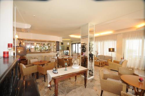 a restaurant with tables and chairs and a bar at Hotel Avana in Riccione