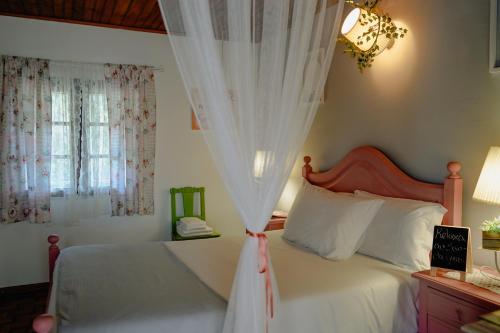 ein Schlafzimmer mit einem weißen Bett mit Baldachin in der Unterkunft TEA HOUSE GERÊS in Geres