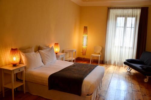 a bedroom with a bed with two lamps and a chair at Al Cavour 34 in Trento