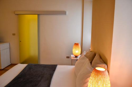 a bedroom with a bed with two lamps on it at Al Cavour 34 in Trento